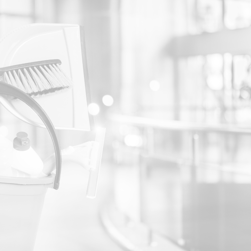 Reinigungsutensilien stehen in einem öffentlichen Innenbereich; der Hintergrund ist unscharf.