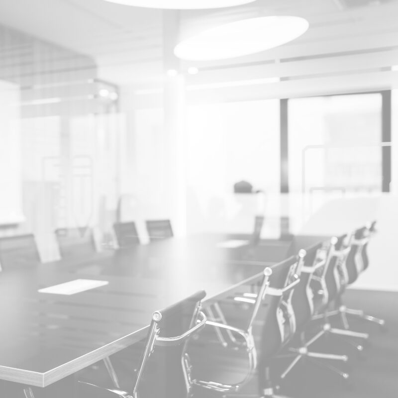 Moderner Besprechungsraum mit Konferenztisch und Stühlen, bereit für den Arbeitstag.